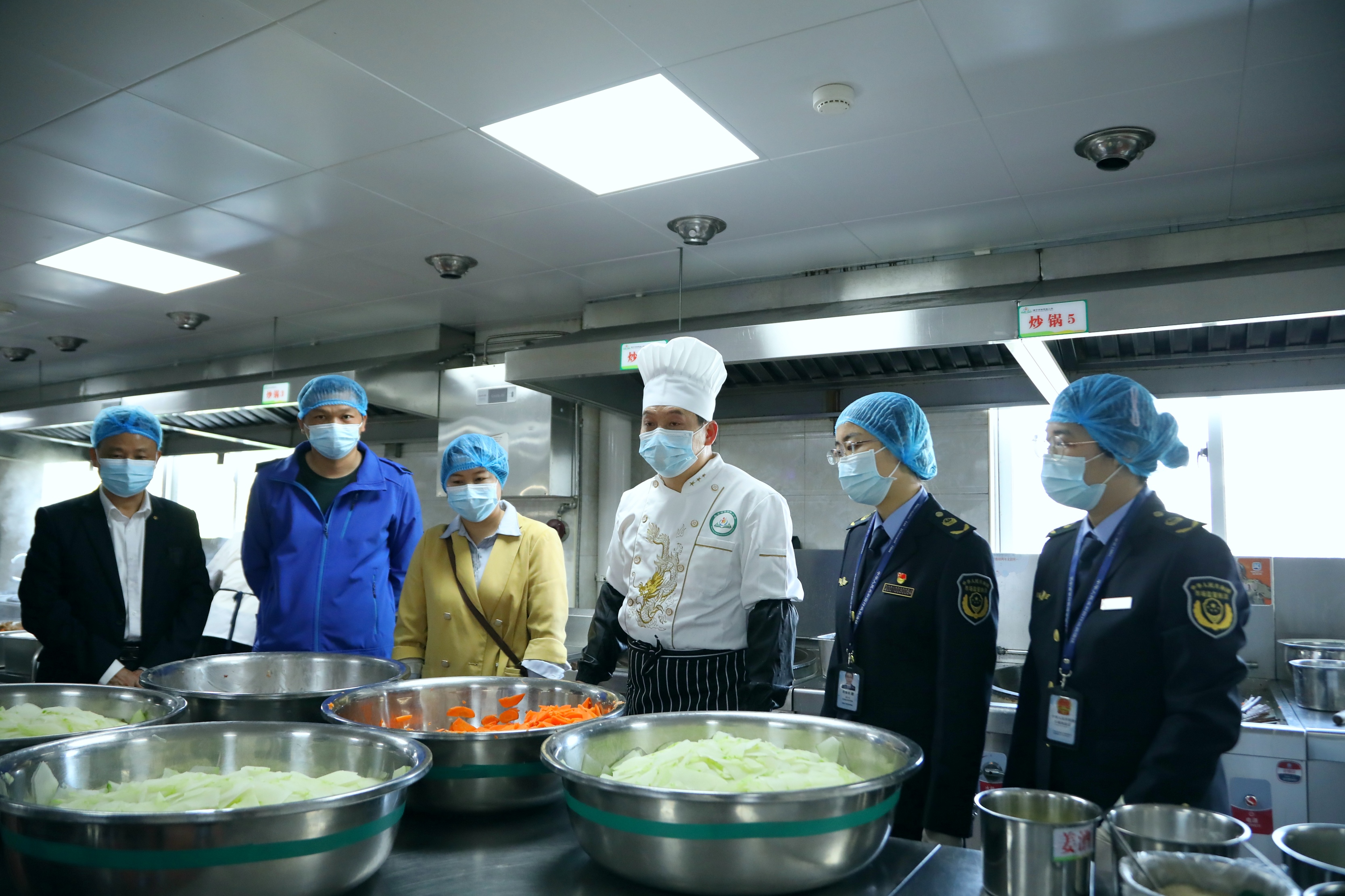 南寧市市場監(jiān)管局高新分局執(zhí)法人員對學(xué)校食堂后廚進(jìn)行檢查。（何正君 攝）.jpg