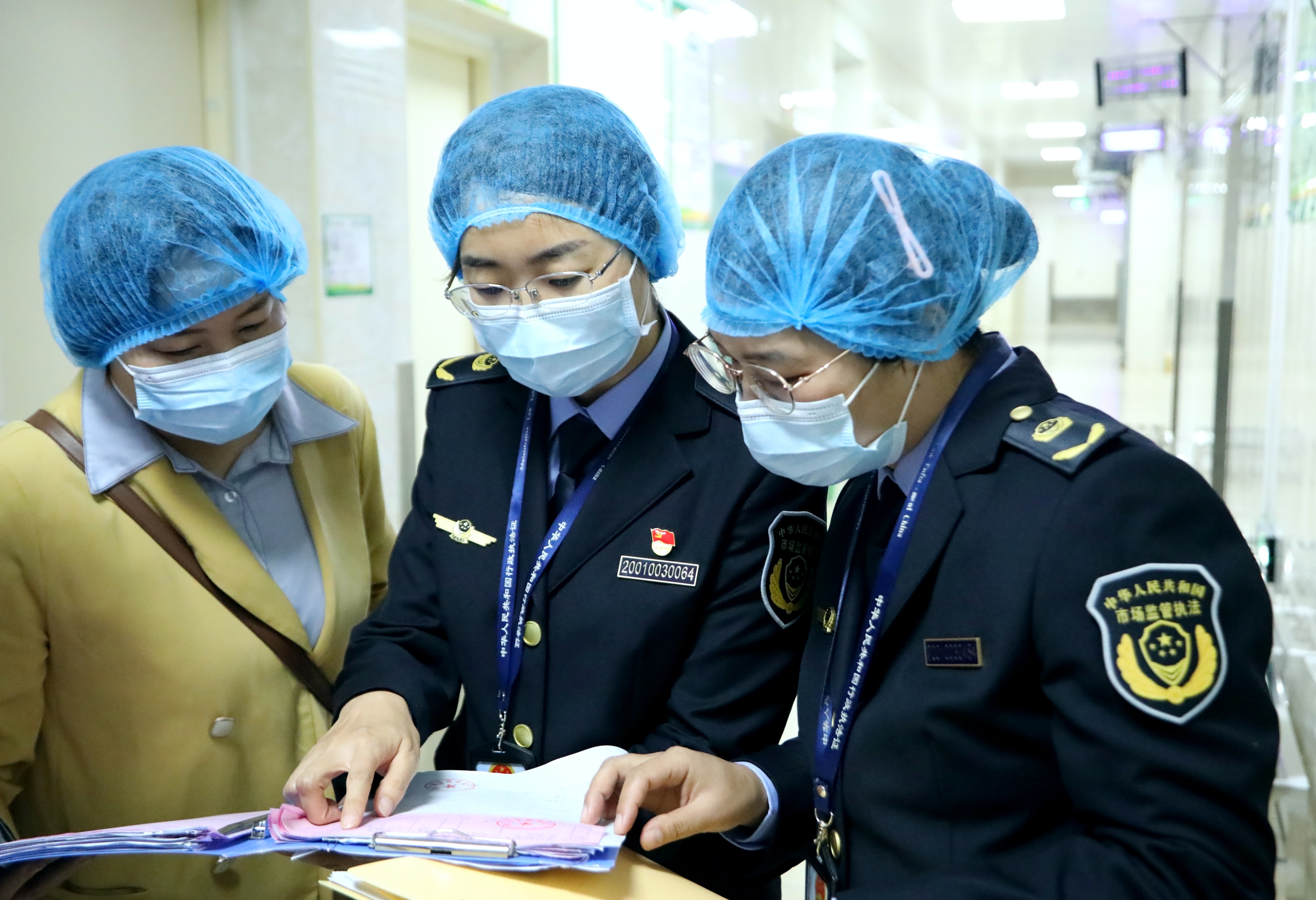 南寧市市場監(jiān)管局高新分局執(zhí)法人員對食堂的采購臺賬及索票索證檔案進(jìn)行檢查。（何正君  攝）.jpg